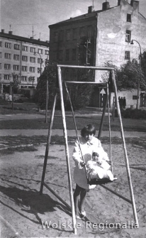 Dziewczynka z dzieckiem na huśtawce na placu zabaw przy ul. Wolskiej