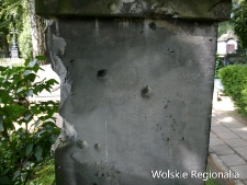 Nagrobek na cmentarzu ewangelicko-reformowanym z widocznymi śladami walk z czasów II wojny światowej