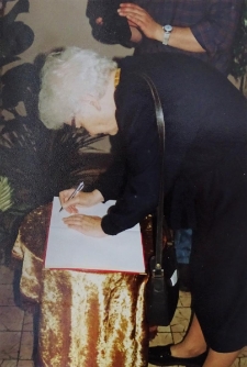 Wnuczka Henryka Sienkiewicza składająca podpis w księdze pamiątkowej Liceum