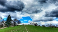 Widok na Kopiec Moczydłowski. Zdjęcie pt. ,,Bezchmurne okienko na kopcu" wykonane w ramach konkursu "Foto Art Wola" przez Łukasza Kozłowskiego